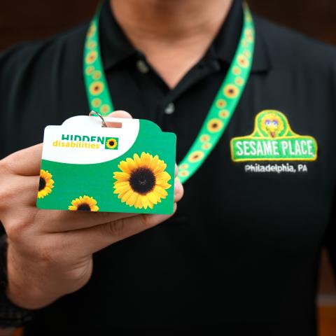 person holding badge with Sesame Logo